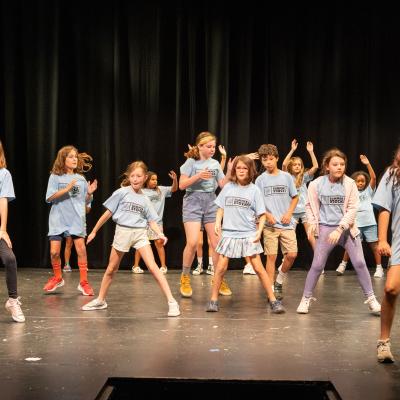 A group of young kids in the middle of a dance routine