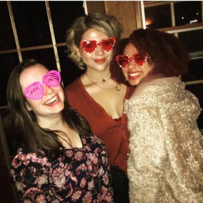 A photo of Kristina, Elynora, and Taylor wearing heart-shaped sunglasses at the Valentine's Day party 