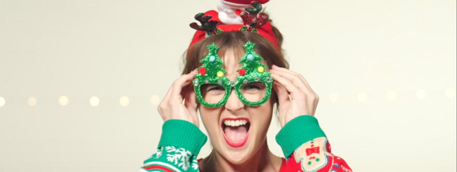 Patricia Hurley in The Most Wonderful Time of the Year wearing a silly red holiday sweater and pine tree shaped glasses.