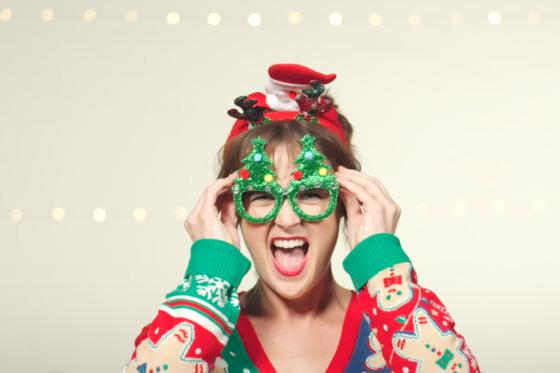 Patricia Hurley in The Most Wonderful Time of the Year wearing a silly red holiday sweater and pine tree shaped glasses.